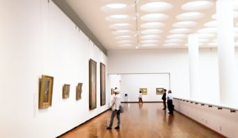 corner of large room with paintings on the wall